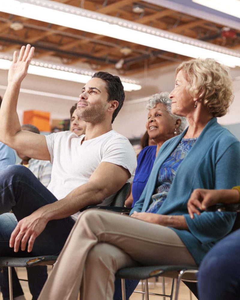Man Asking Question At Neighborhood Meeting In Community Center